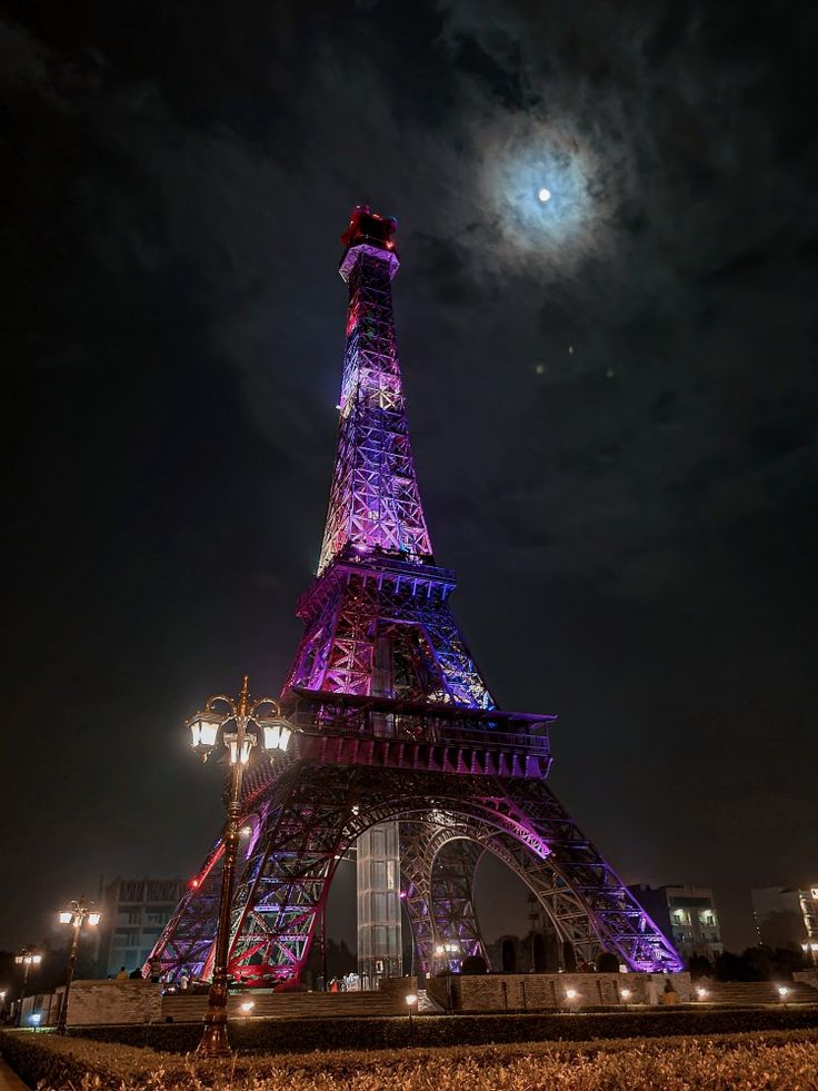 the eiffel tower is lit up in purple