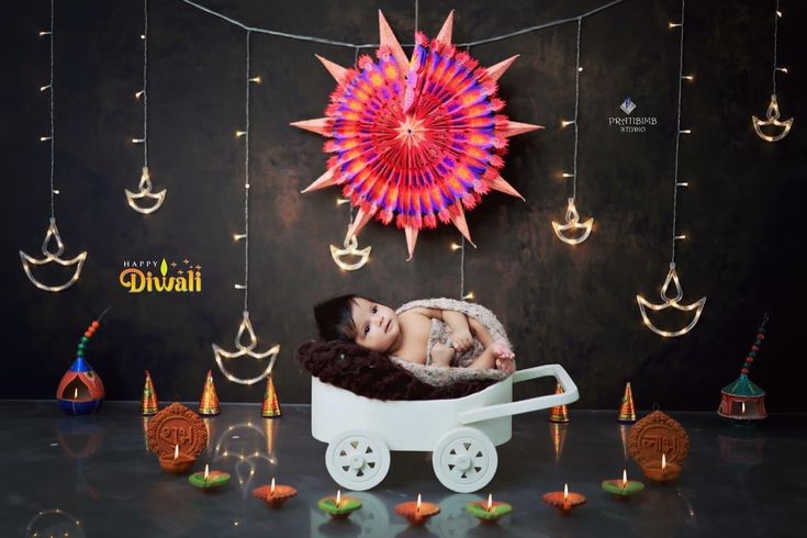 a baby is sleeping in a wagon with decorations around it and lights on the wall