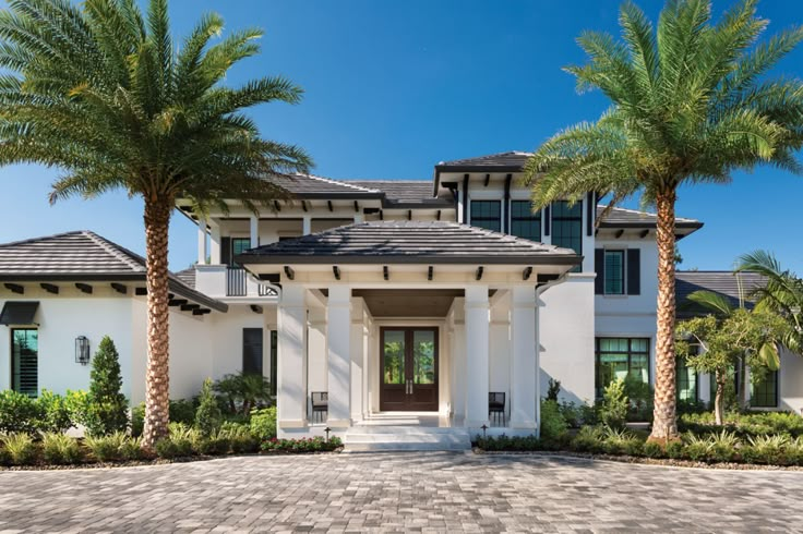 a large white house with palm trees in front