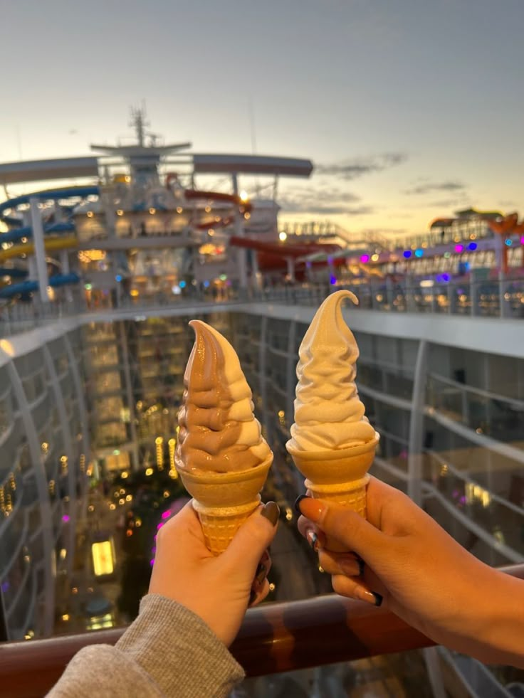 two people holding ice cream cones in their hands