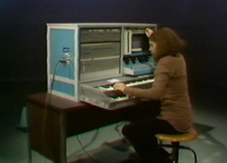 a person sitting at a desk with an electronic keyboard