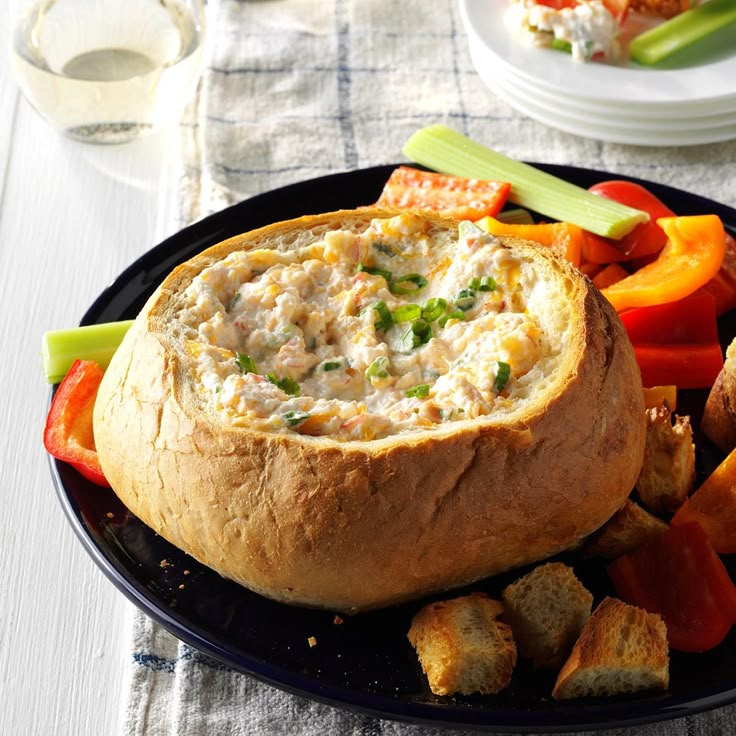 a black plate topped with bread and veggies