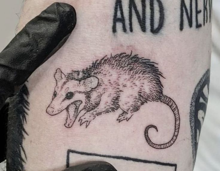 an arm with a rat tattoo on it