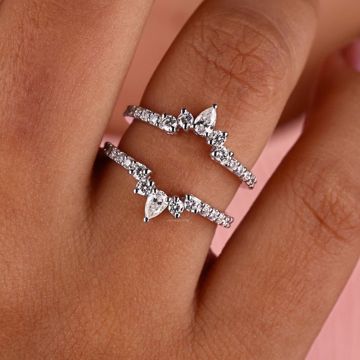 a woman's hand with three diamond rings on her finger and one ring in the middle