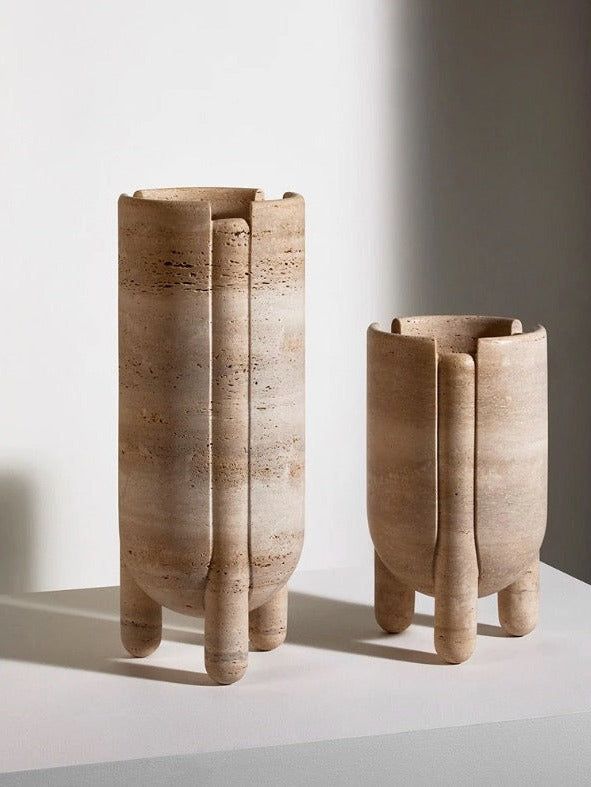 two wooden vases sitting next to each other on a white countertop in front of a window