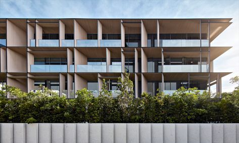 an apartment building with many balconies on the sides and trees in front of it