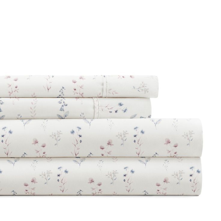 three sheets with floral designs on them, one in white and the other in blue