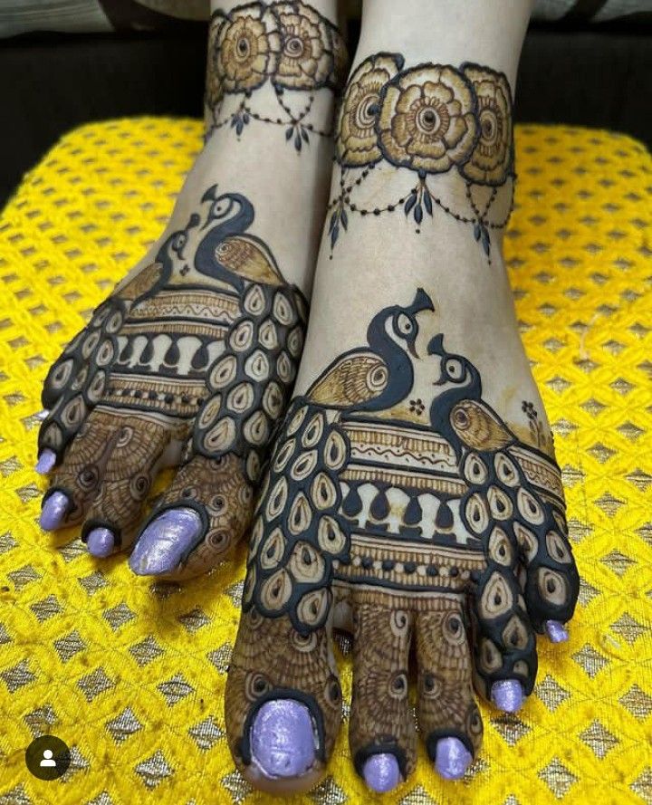 the feet and hands of a woman with henna tattoos on their legs, decorated with peacocks