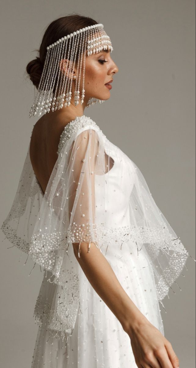 a woman in a white dress wearing a beaded veil