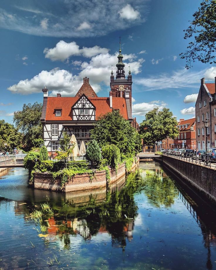 a river running through a small town next to tall buildings with towers on each side