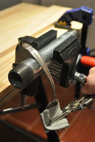 a person is using a pair of pliers to cut wood with a viset