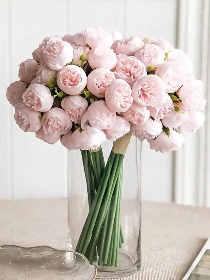 a vase filled with pink flowers on top of a table