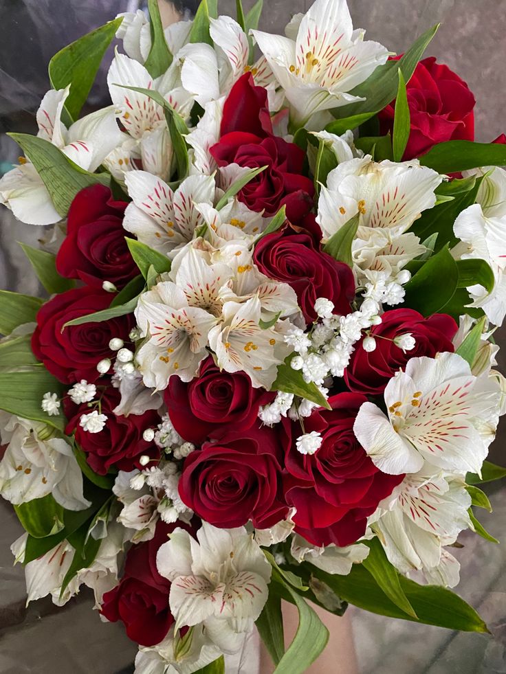 a bouquet of red roses and white lilies