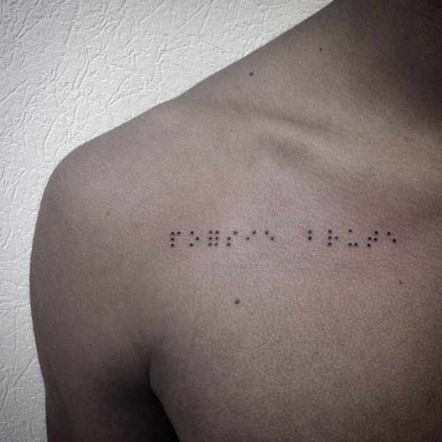 the back of a man's chest with small dots on it that spell out love