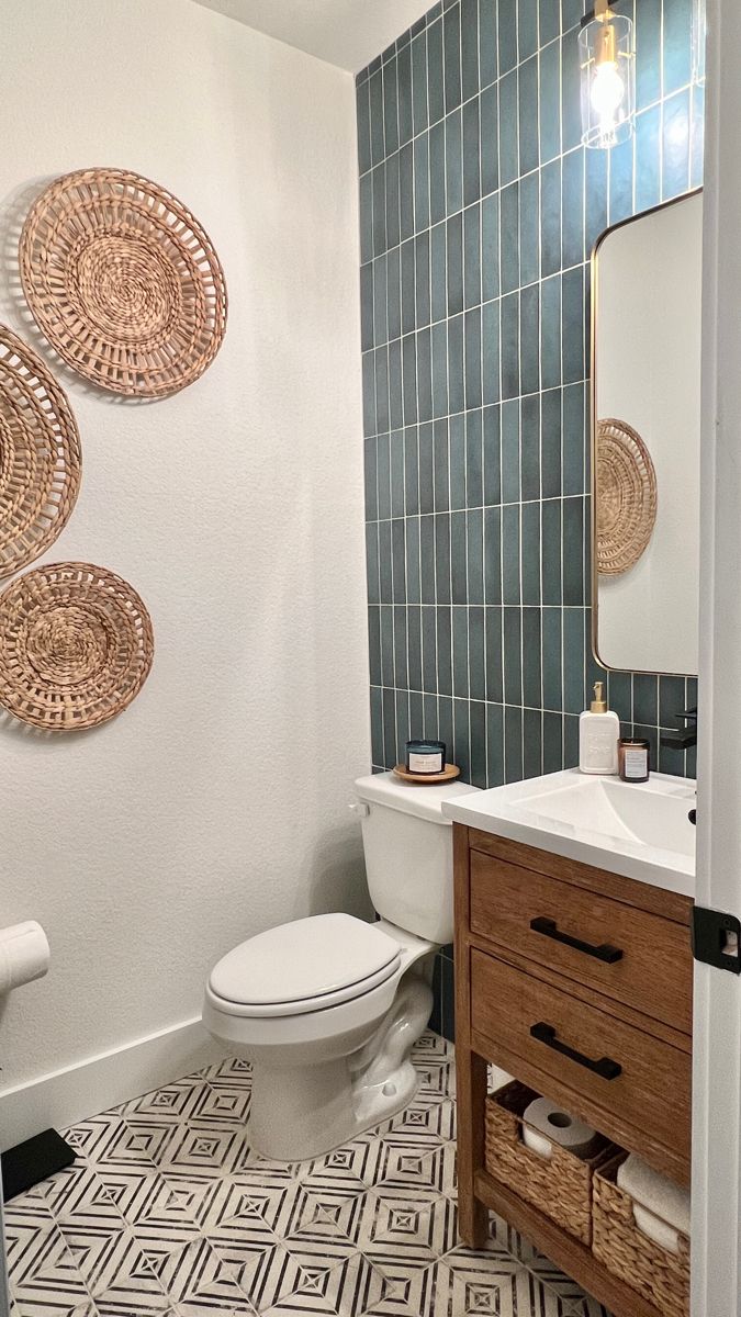 a white toilet sitting next to a sink in a bathroom under three round wall hangings