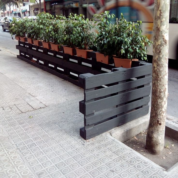 the planters are lined up on the side of the street by the bus stop