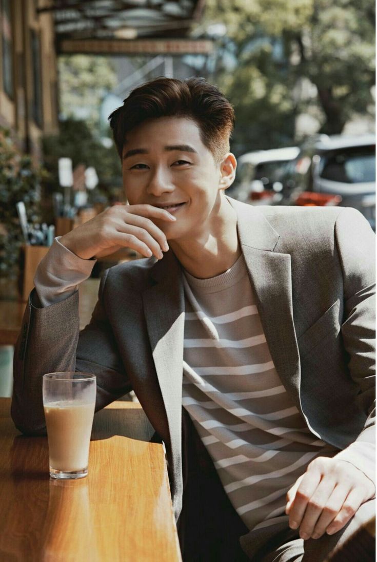 a young man sitting at a table with a glass of milk in front of him