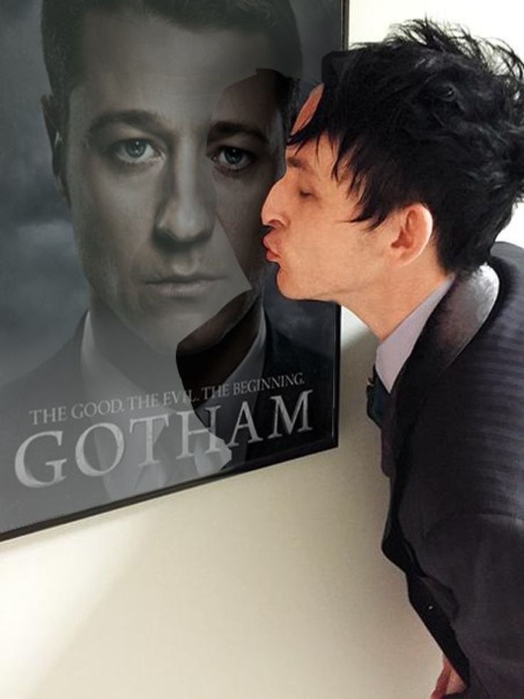 a man kissing the nose of another man in front of a poster