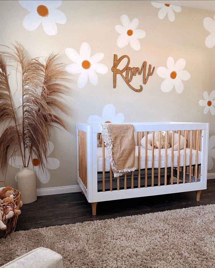 a baby's room with flowers on the wall and a crib in the foreground