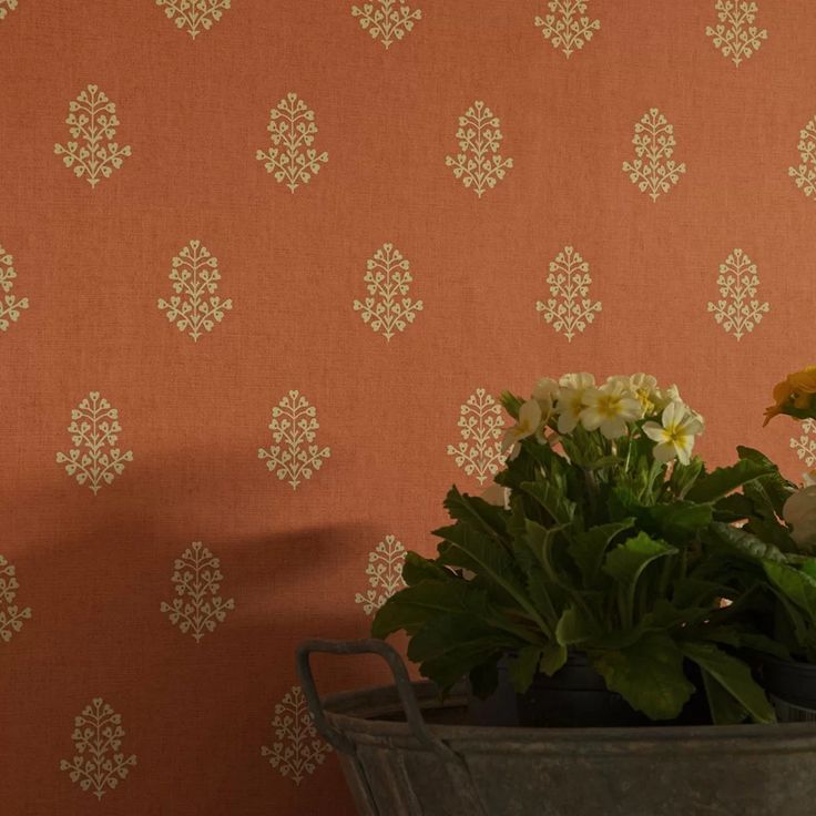 a potted plant sitting on top of a wooden table next to a wallpaper