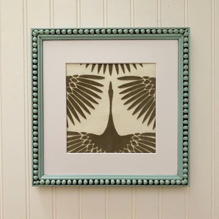 an image of a bird in a frame on the wall