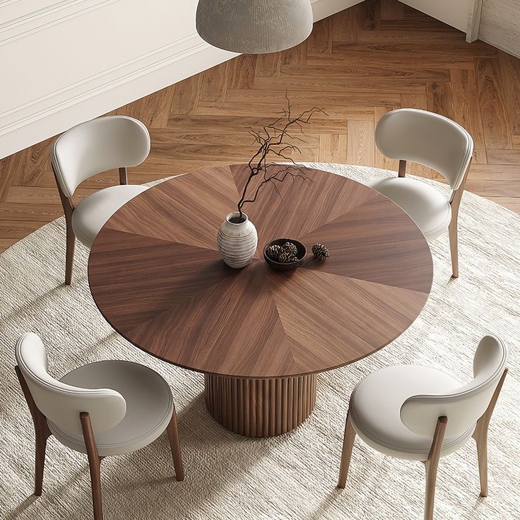 a round wooden table with white chairs around it