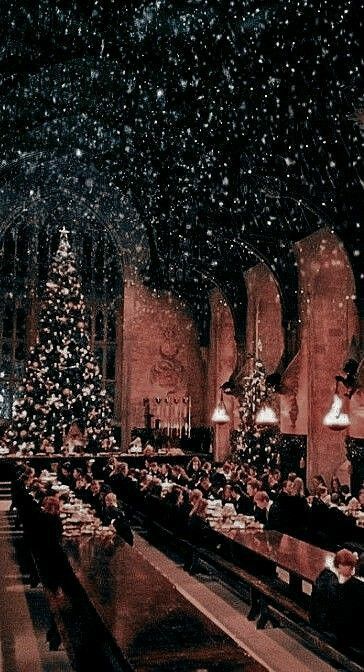 people sitting at tables in a church with christmas decorations on the ceiling and lights hanging from the ceiling