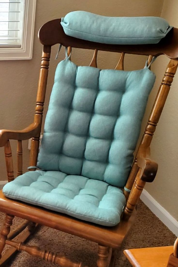 a rocking chair with a blue cushion on it's back and seat pad in the middle