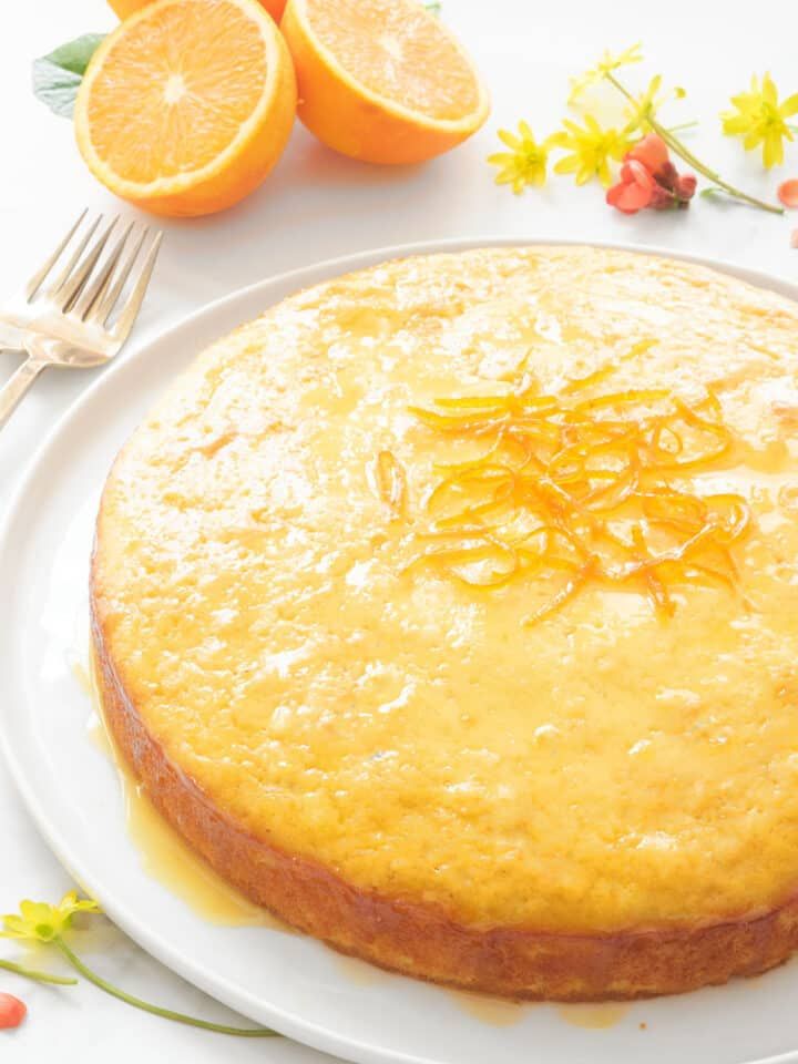 a cake on a plate with oranges next to it