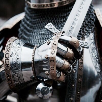 a close up of a person's hand wearing armor