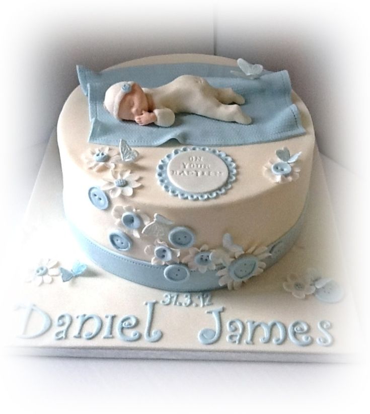 there is a cake that has a baby sleeping on top of it with the name daniel james