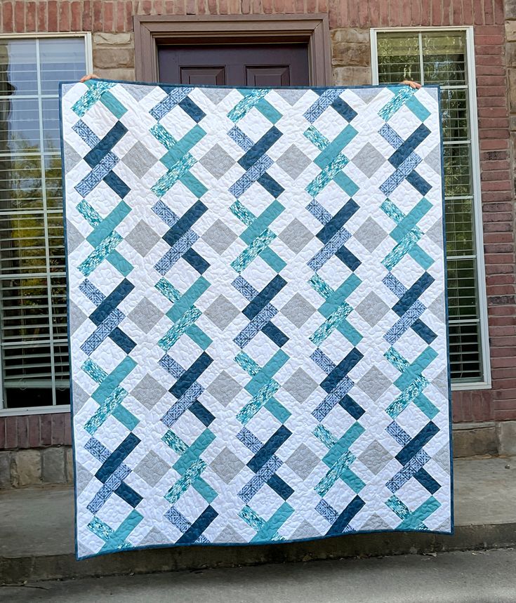 a blue and white quilt on the side of a building