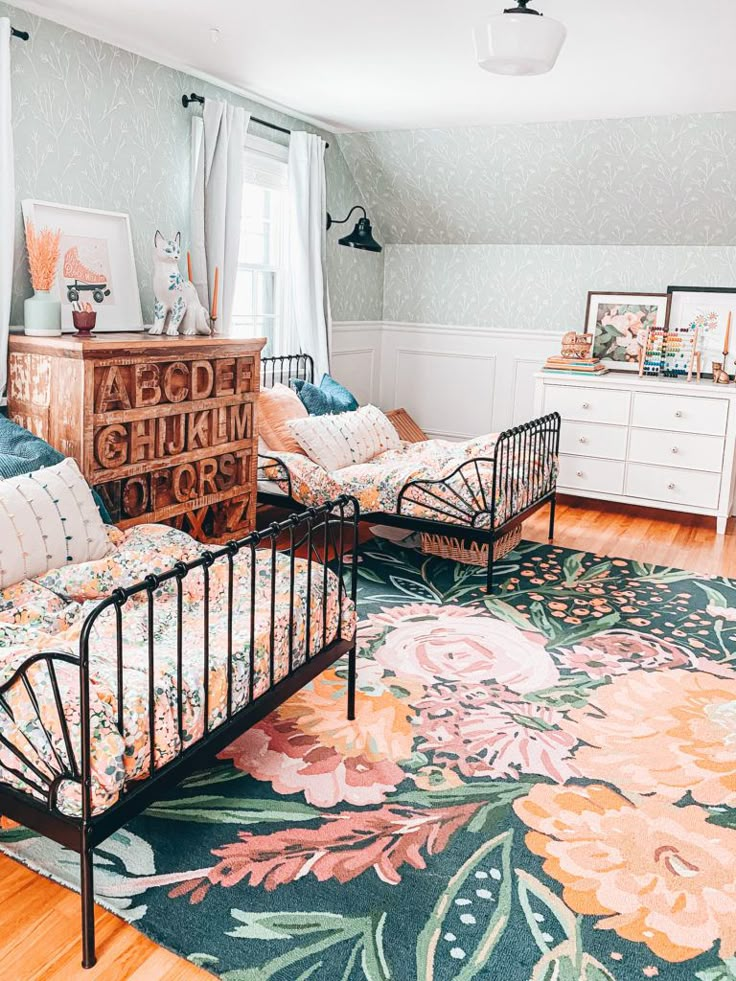 a bedroom with two beds and a rug on the floor in front of it,