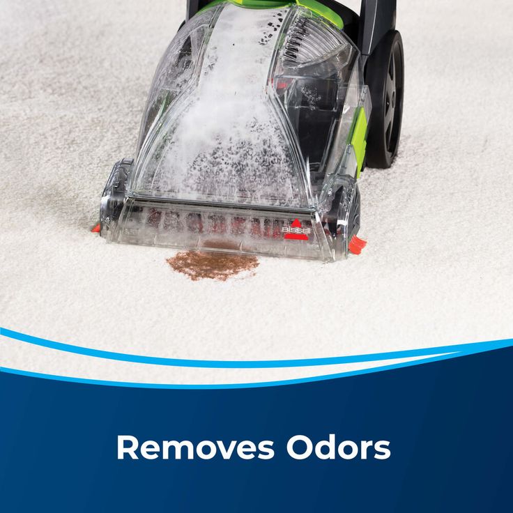 a person vacuuming the carpet with a green and black hoovers odous