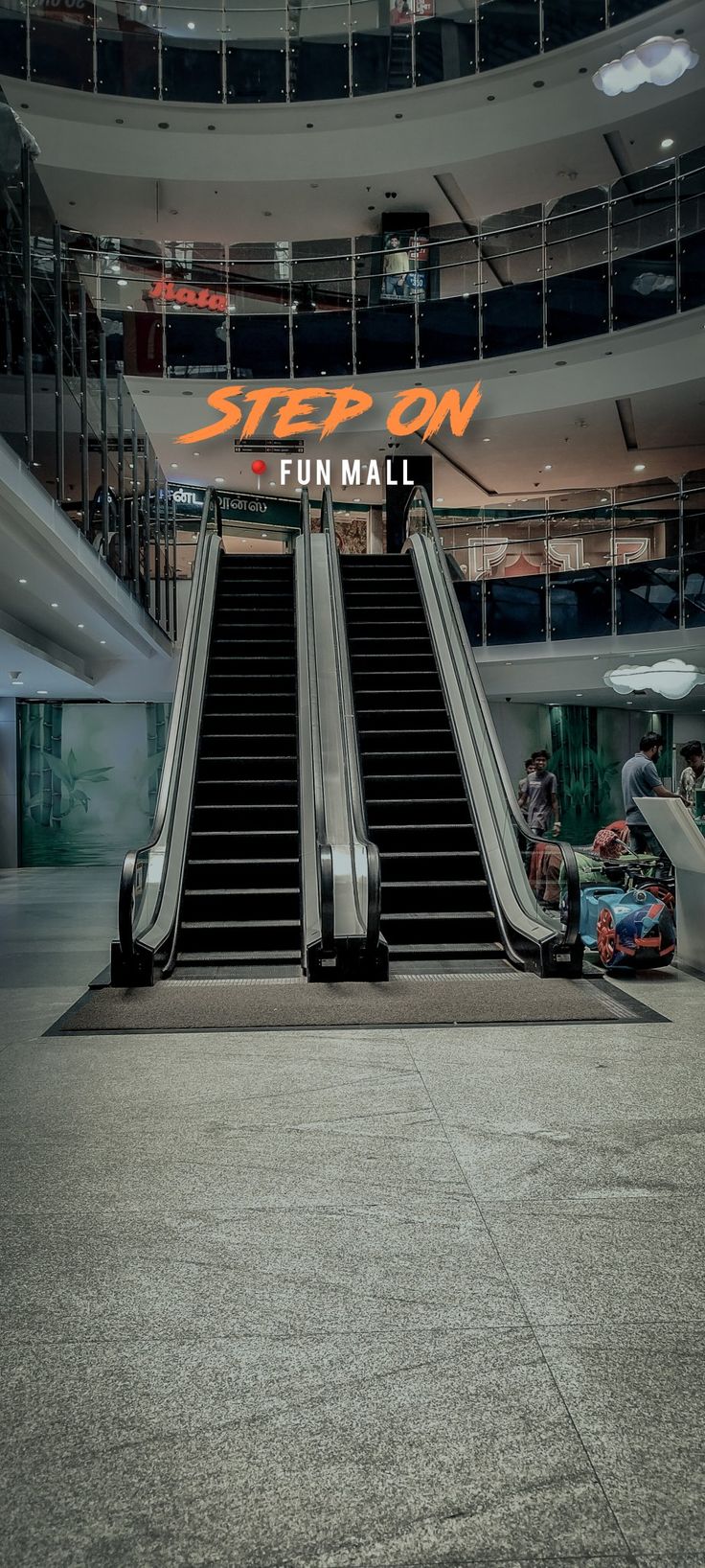 an escalator with two people riding down it in front of a sign that reads step on fun mall