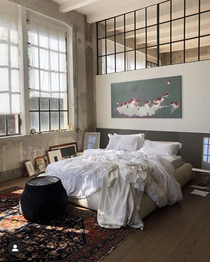 an instagram photo of a bed with white sheets and pillows in a loft bedroom