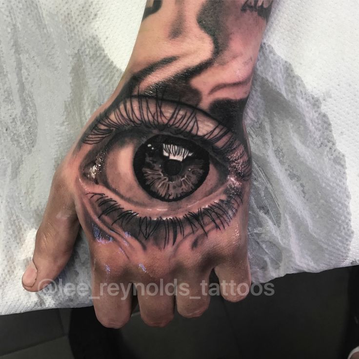 a person's hand with an eye tattooed on it