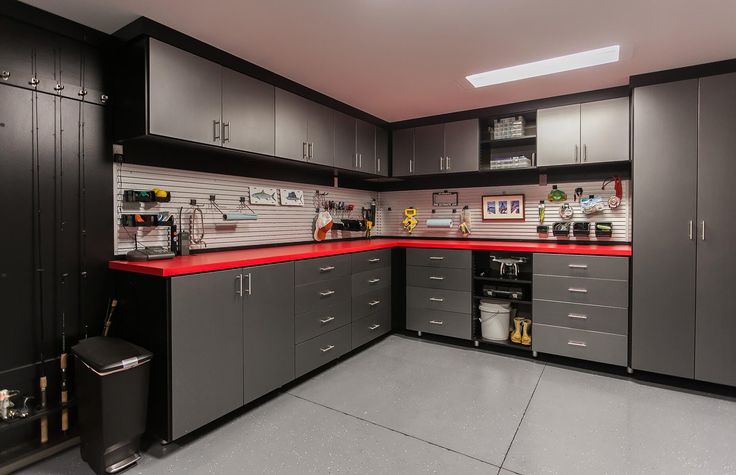 a kitchen with gray cabinets and red counter tops in the center is an empty trash can