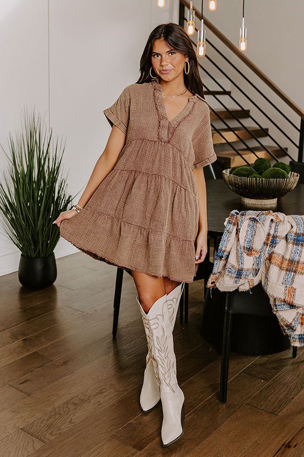 - Go with the flow in this casual dress! - Unlined mineral washed material with a subtle texture - A collared v-cut neckline with stitching for additional coverage and frayed accents - Short sleeves with rolled cuffs - A relaxed silhouette that ends in mini dress length, unfinished, frayed hemline Casual Brown V-neck Mini Dress, Brown Cotton V-neck Mini Dress, Western Boho Chic, Go With The Flow, Western Boho, Subtle Textures, V Cut, V Cuts, Mocha