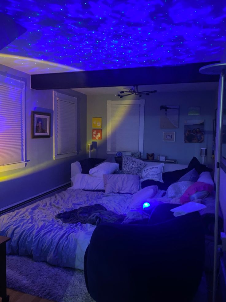 a bed room with a couch and a night sky light on the ceiling above it