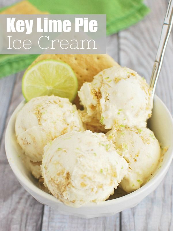 a bowl filled with ice cream next to a lime slice and cracker on the side