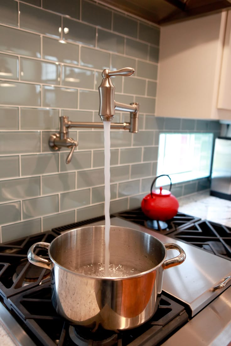 a pot on the stove with water running from it's faucet to the side