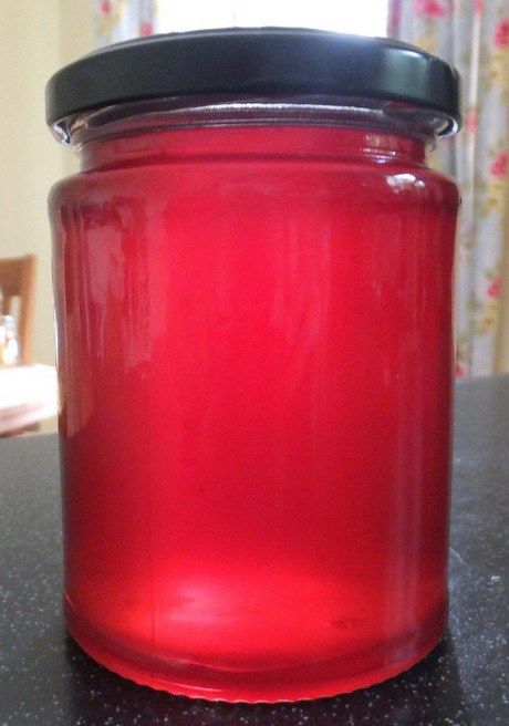 a red glass jar sitting on top of a counter next to a black countertop