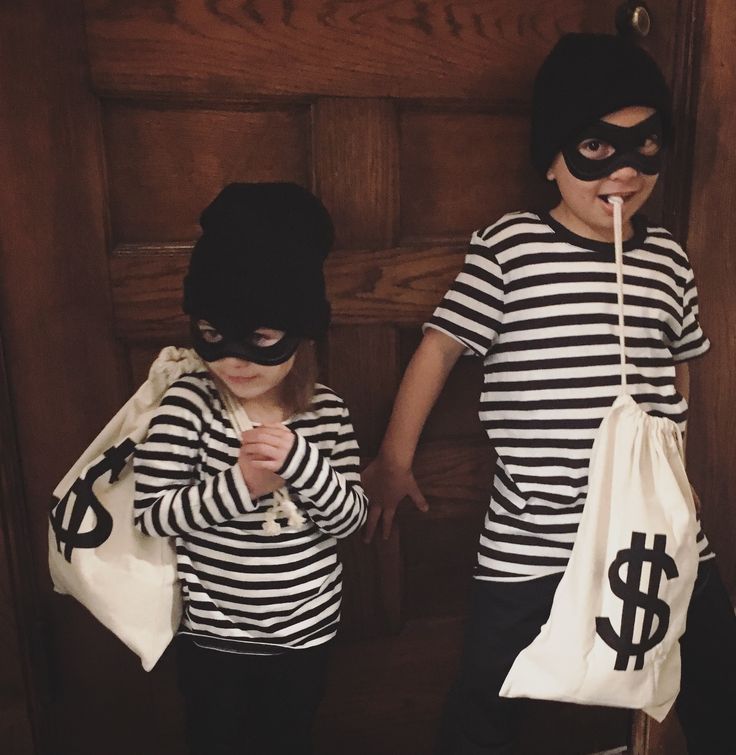 two children dressed up as burgle and money bags, one with a straw in his mouth