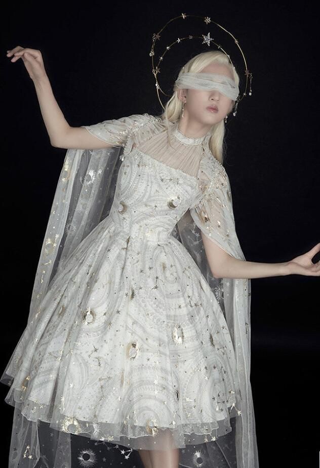 a woman in a white dress and veil with stars on her head is posing for the camera