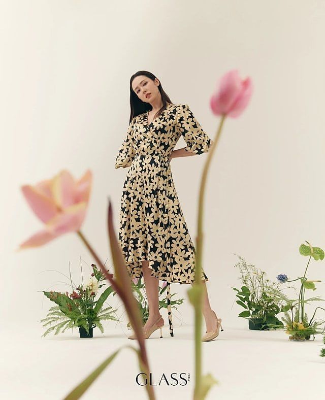 a woman standing in front of some flowers