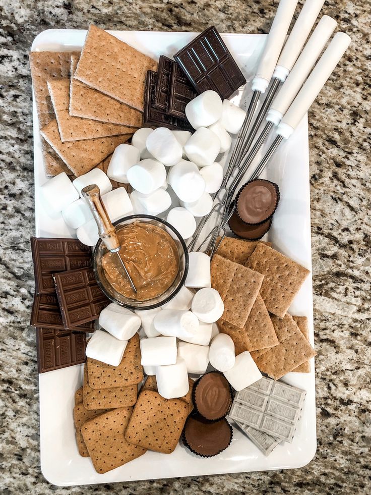 a white plate topped with marshmallows and crackers