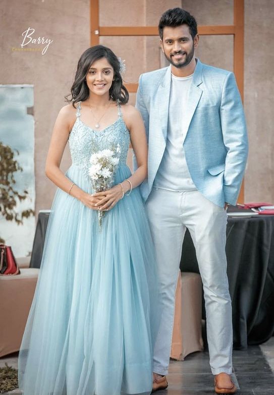 two people standing next to each other in front of a table with flowers on it