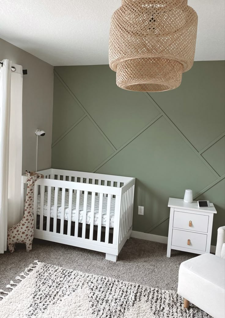 a baby's room with a white crib and green walls