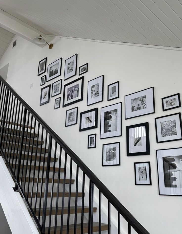 a staircase with black and white pictures on the wall